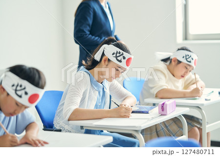 必勝はちまきをして勉強する子供たち 127480711