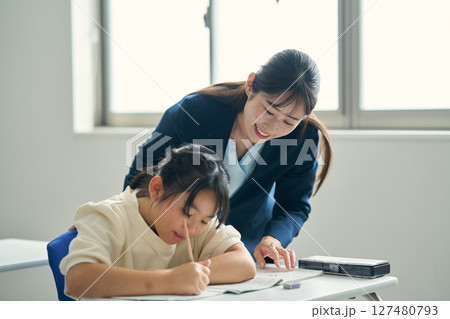 学習塾で子供に指導する講師 127480793