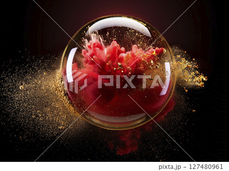 球体の液体の中で赤い色と金粉が爆発する 127480961