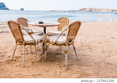 Outdoor cafe or restaurant with sea view and empty chairs. Coastal relaxation, summer tourism, and beachfront dining in the Mediterranean region. Outdoor cafe or restaurant with sea view and empty chairs. Coastal relaxation, summer tourism, and beachfront dining in the Mediterranean region. 127481100