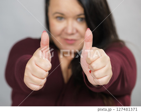 Woman making thumb up gesture 127481371