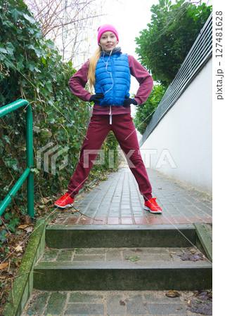 Woman wearing sportswear exercising outside during autumn 127481628