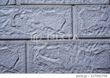 Textured grey faux brick wall panel background close up Textured grey faux brick wall panel background close up 127481709
