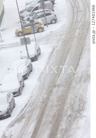 Road and parked cars covered in snow after blizzard Road and parked cars covered in snow after blizzard 127481966