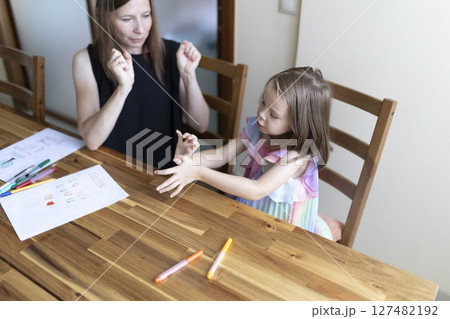Speech therapist helping young girl with pronunciation and communication skills 127482192