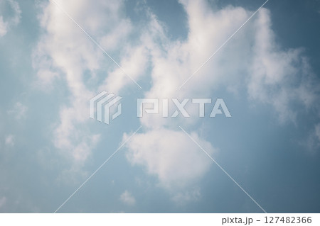Fluffy white clouds floating in a bright blue sky Fluffy white clouds floating in a bright blue sky 127482366