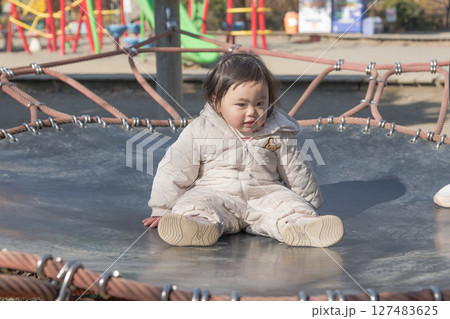 【相模原市立麻溝公園の子どもの広場のトランポリンで遊ぶ1歳児】 127483625