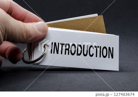 Hand flipping a notebook page with visible INTRODUCTION label Hand flipping a notebook page with visible INTRODUCTION label 127483674