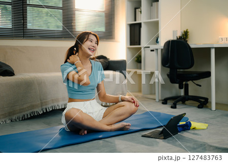 Relaxed woman cooling down after exercise on yoga mat. Wellness concept Relaxed woman cooling down after exercise on yoga mat. Wellness concept 127483763
