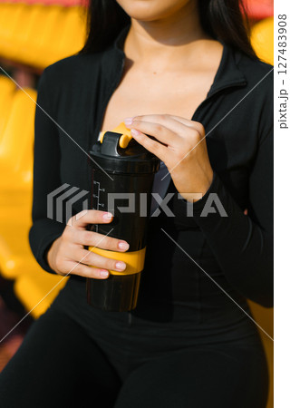 Woman Holding Black And Yellow Shaker Woman Holding Black And Yellow Shaker 127483908