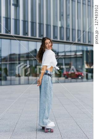 Girl Standing On Skateboard Outdoors Girl Standing On Skateboard Outdoors 127483912