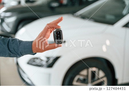 Hand is holding the keys. Close up view of man that is with electrical car Hand is holding the keys. Close up view of man that is with electrical car 127484431