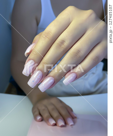 Nail extensions, manicure, nail correction, hands in the foreground gel polishes Nail extensions, manicure, nail correction, hands in the foreground gel polishes 127485107