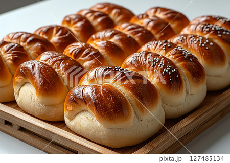 Yummy baked bread. Variety of baked buns in on a wooden trading tray on a white background. 127485134
