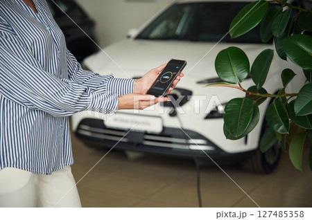 Conception of green energy. Smartphone with charging process data. Close up view of woman Conception of green energy. Smartphone with charging process data. Close up view of woman 127485358