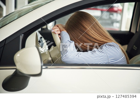 Sitting tired. Close up view of woman that is with electric car 127485394