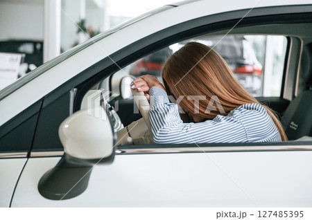 Sitting tired. Close up view of woman that is with electric car 127485395