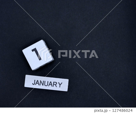 Wooden calendar, January 1, New Year's Day on black background Wooden calendar, January 1, New Year's Day on black background 127486024
