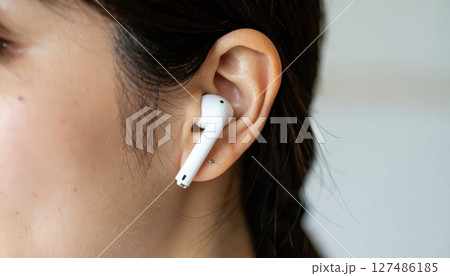 《AI画像》Bluetoothイヤホンを付けた女性のクローズアップ 127486185