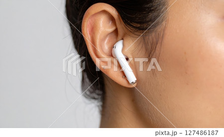 《AI画像》Bluetoothイヤホンを付けた女性のクローズアップ 127486187