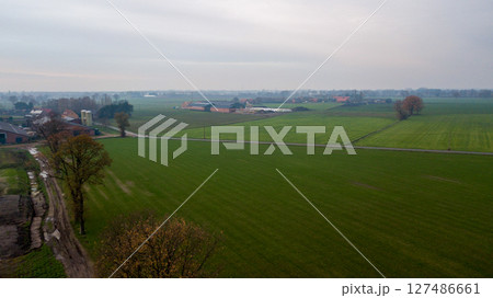 Vast Expansive Green Fields Stretching Under a Moody, Cloudy Sky Above the Landscape 127486661
