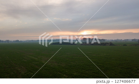Aerial view on a dramatic and colorful sunrise or sunset sky over a grassy green farmfield shot from Aerial view on a dramatic and colorful sunrise or sunset sky over a grassy green farmfield shot from 127486677