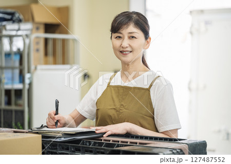 スーパーのバックヤードで働くミドル女性のポートレート スーパーのバックヤードで働くミドル女性のポートレート 127487552