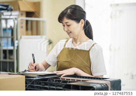 バックヤードで伝票をチェックするミドル女性 127487553
