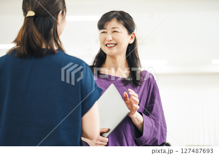 同僚と楽しく話す50代のキャリアウーマン 127487693