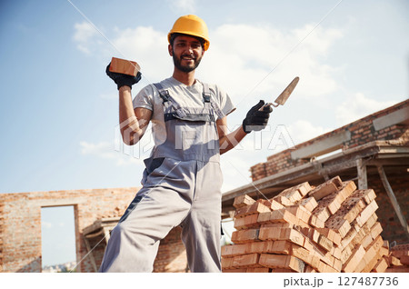 Cheerful and handsome Indian man is on the construction site Cheerful and handsome Indian man is on the construction site 127487736