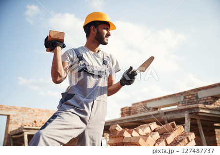Outdoors at daytime. Handsome Indian man is on the construction site Outdoors at daytime. Handsome Indian man is on the construction site 127487737