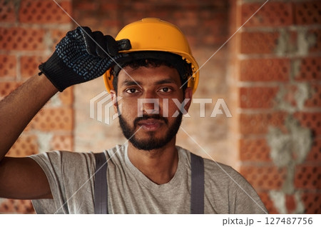 Portrait of handsome Indian man that is on the construction site 127487756