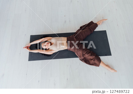 Fitness Woman Brunette Doing Gymnastics Yoga Asana in White Hall Fitness Woman Brunette Doing Gymnastics Yoga Asana in White Hall 127489722