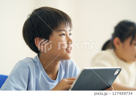 タブレット端末を操作する小学生 127489734