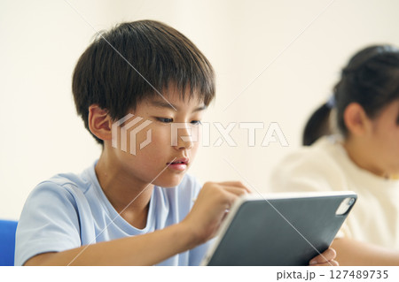 タブレット端末を操作する小学生 127489735