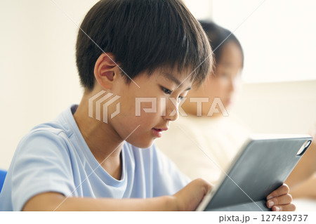 タブレット端末を操作する小学生 127489737