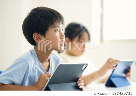 タブレット端末を操作する小学生 127489739