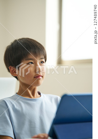 タブレット端末を操作する小学生 127489740