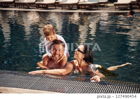 Front view. Happy family of father, mother and son are in the pool 127490454