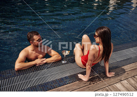 Man with woman is in the pool together Man with woman is in the pool together 127490512