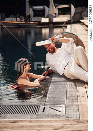 Man with woman is in the pool together Man with woman is in the pool together 127490628