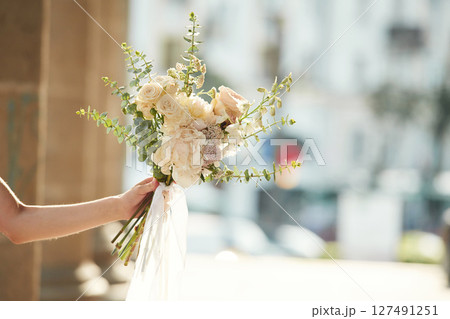 City at background. Close up view of woman that is with flowers in hands 127491251
