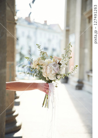 City at background. Close up view of woman that is with flowers in hands 127491263
