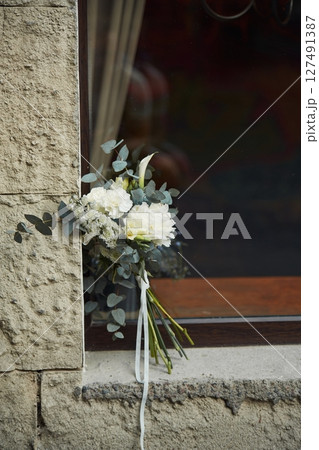 Close up view of flowers that are on the windowsill outdoors 127491387