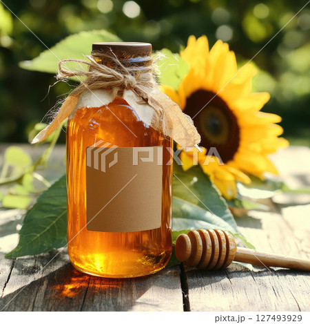 "Close-up of a glass jar filled with golden honey, wooden honey dipper dripping sweet liquid, surrounded by fresh flowers and tea cup, natural and healthy food concept, bright yellow tones, warm light "Close-up of a glass jar filled with golden honey, wooden honey dipper dripping sweet liquid, surrounded by fresh flowers and tea cup, natural and healthy food concept, bright yellow tones, warm light 127493929
