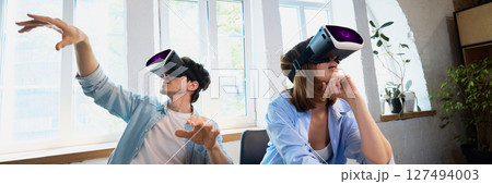 People enjoying virtual reality experience with headsets in bright modern living room People enjoying virtual reality experience with headsets in bright modern living room 127494003