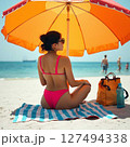 パラソルの下で海を見つめる夏の午後 127494338