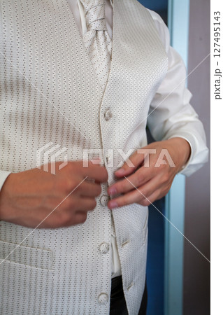 The dapper groom is adjusting the details of his formal attire for the special occasion The dapper groom is adjusting the details of his formal attire for the special occasion 127495143