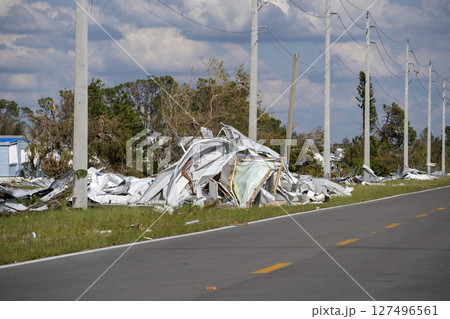 Piles of rubbish on street side from severely damaged houses after hurricane in Florida mobile home residential area. Consequences of natural disaster 127496561