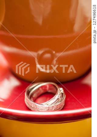 An Elegant Wedding Ring is showcased on a Colorful Plate, highlighting its charm An Elegant Wedding Ring is showcased on a Colorful Plate, highlighting its charm 127496618